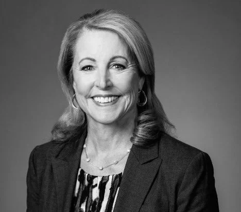 Black and white portrait of Barbara Levy, wearing a blazer and a patterned blouse.