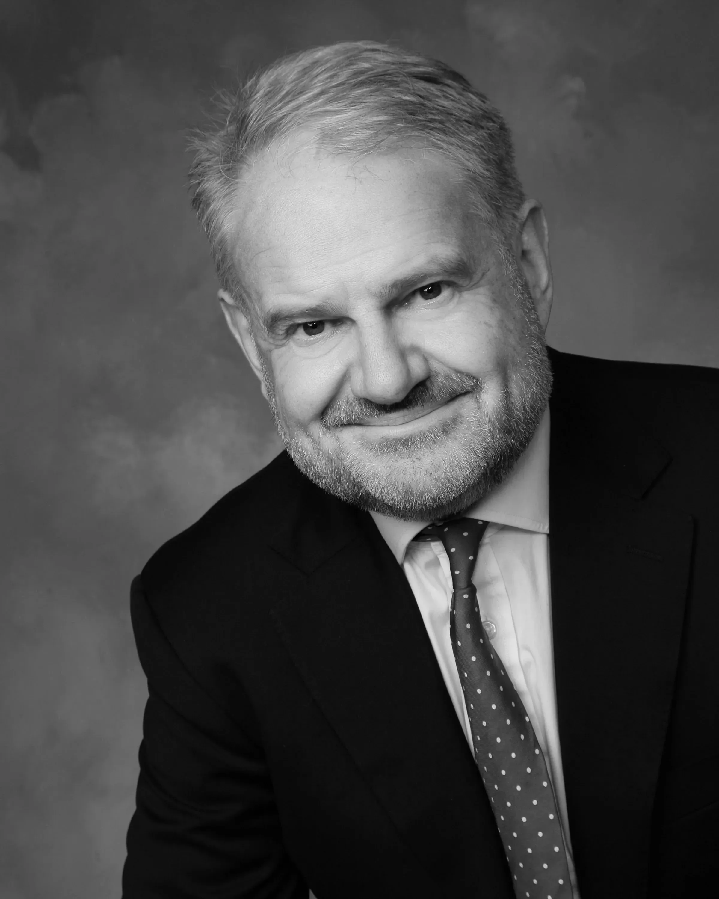 Black and white professional headshot of Charles Kingsland, wearing a suit and tie.