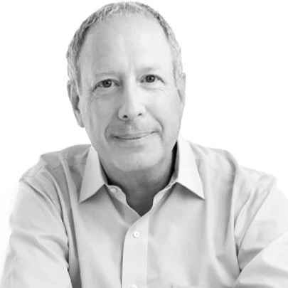 Black and white portrait of David Sable, wearing a collared shirt, smiling slightly at the camera.
