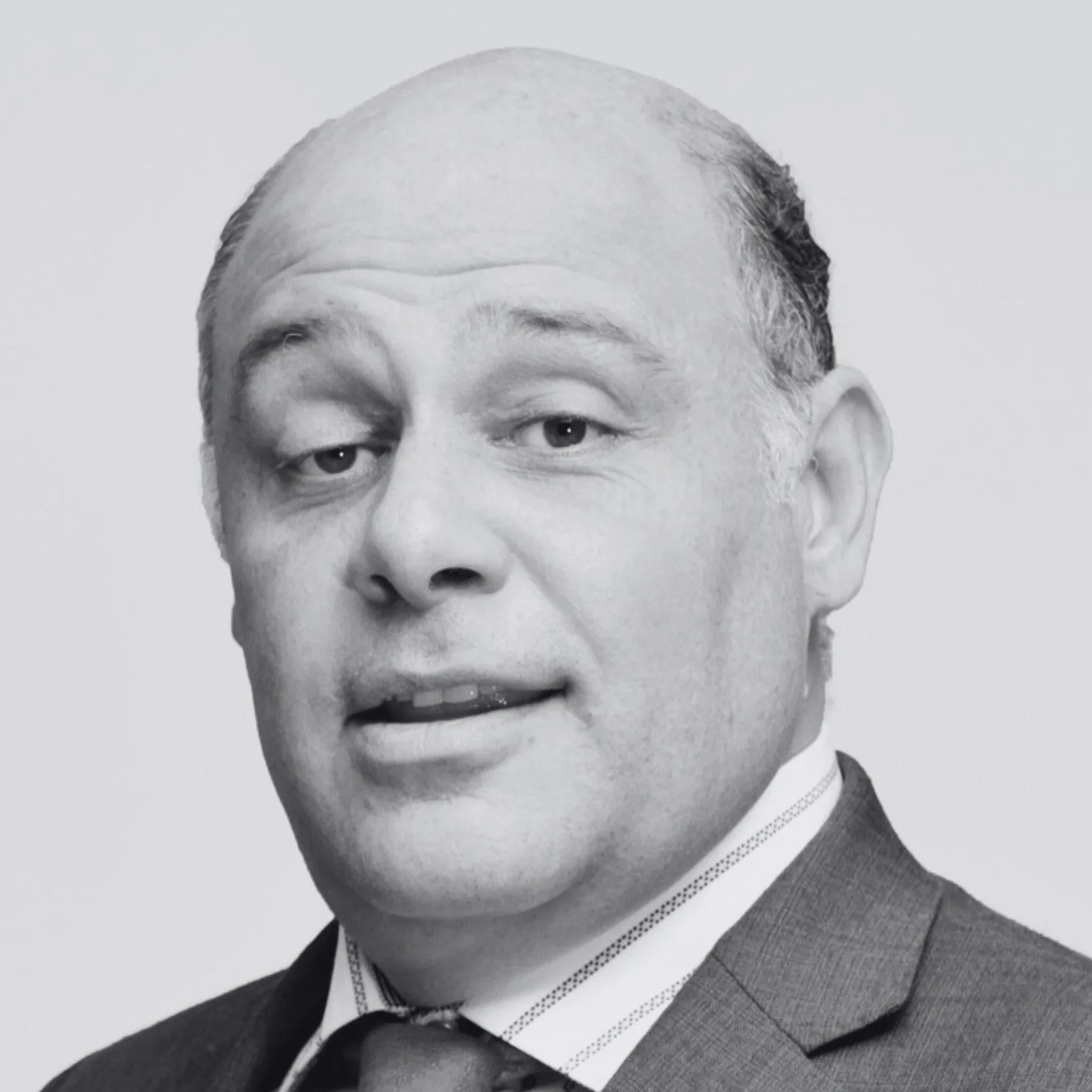 Black and white portrait of Hector Valle Mesto, wearing a suit and tie.