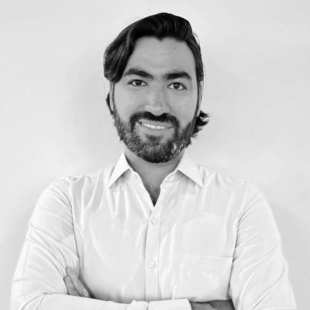 Black and white photo of Isaac Gonzalez wearing a suit and white shirt, smiling.