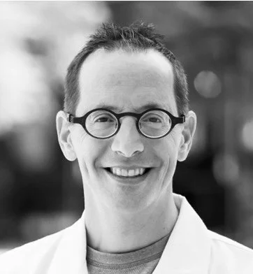 Mitchell Rosen, wearing a white coat, outdoors.