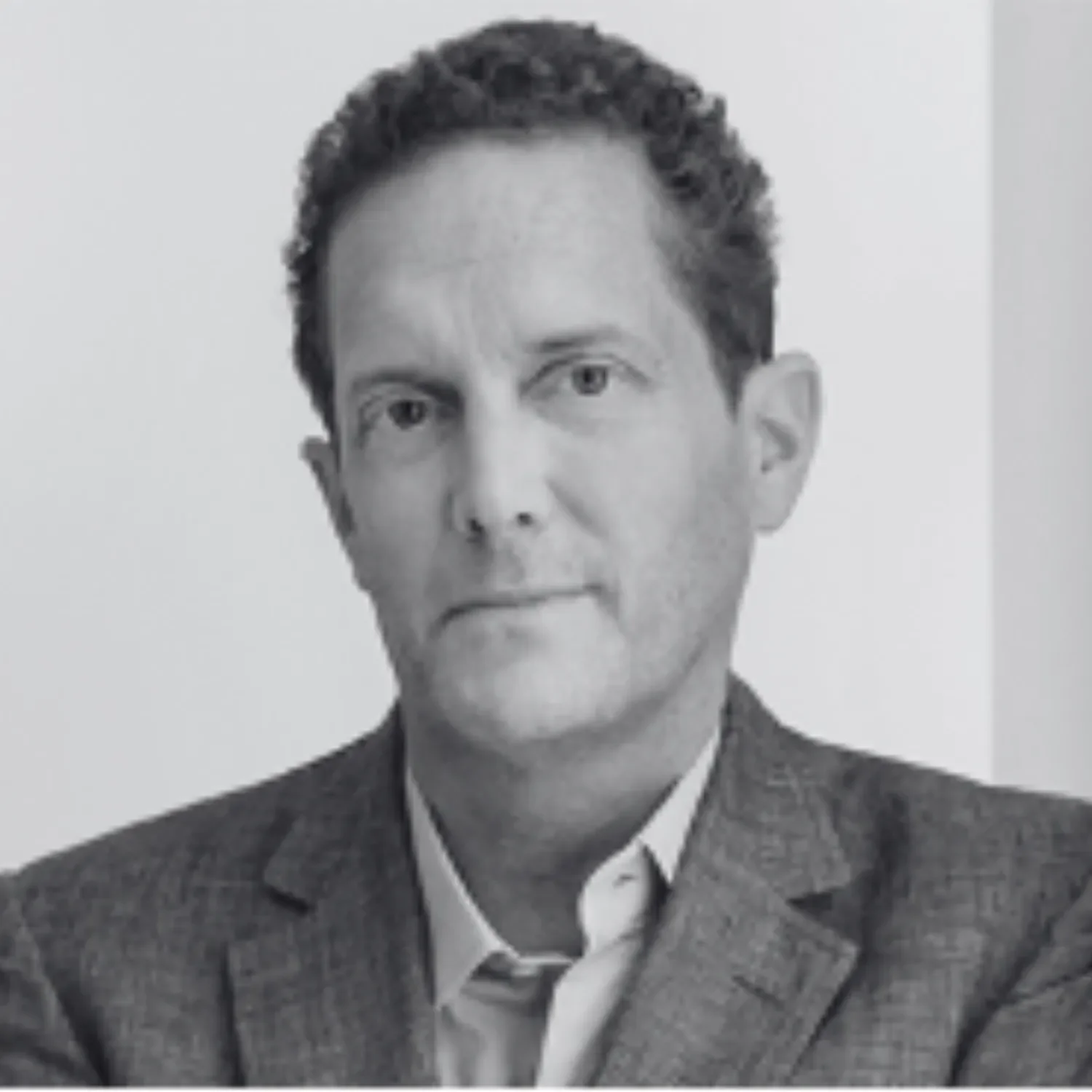 Black and white portrait of Joshua Abram, wearing a suit jacket and a collared shirt.
