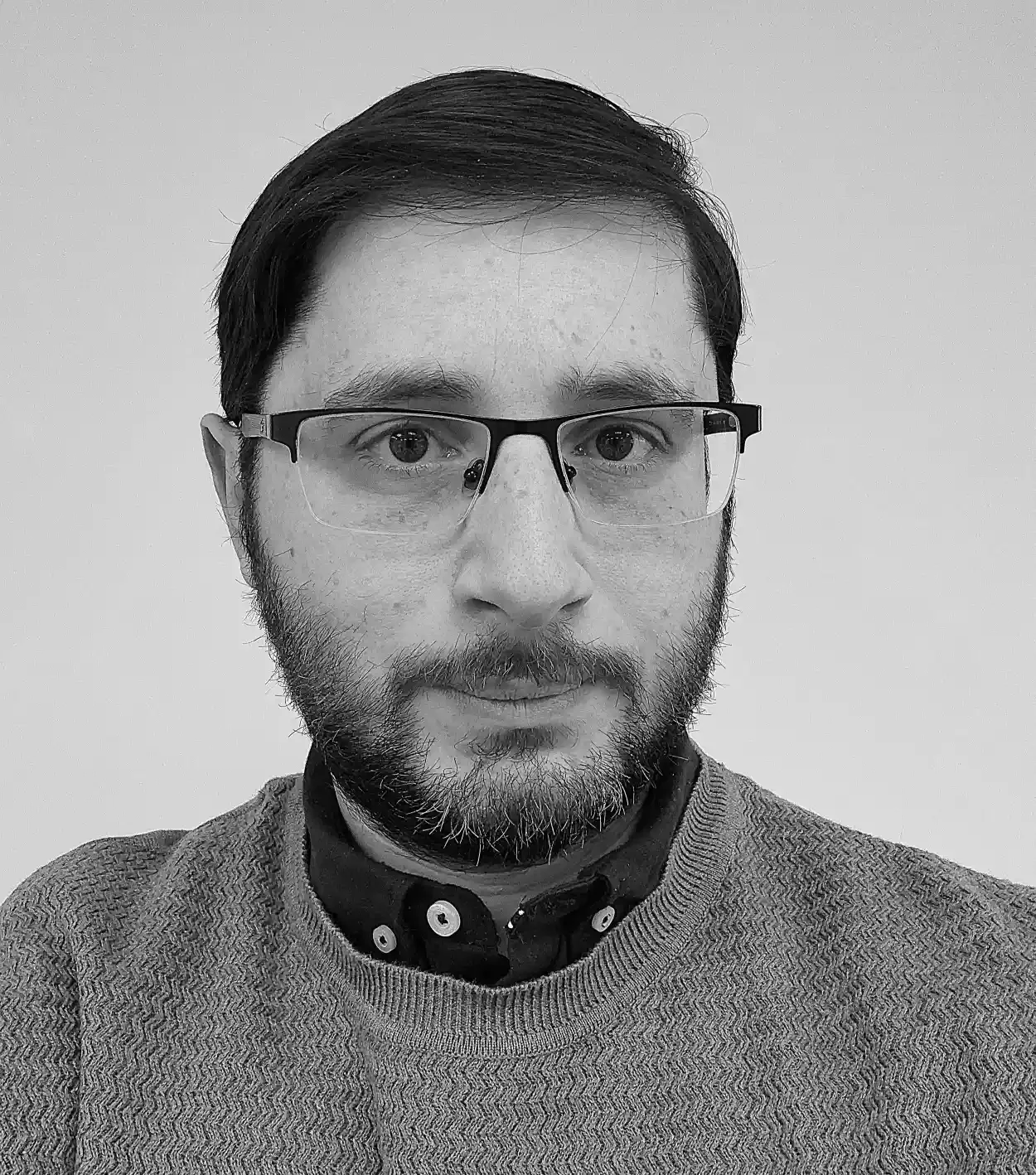 Black-and-white portrait of Guiseppe Silvestri, wearing a sweater over a collared shirt, against a plain background.
